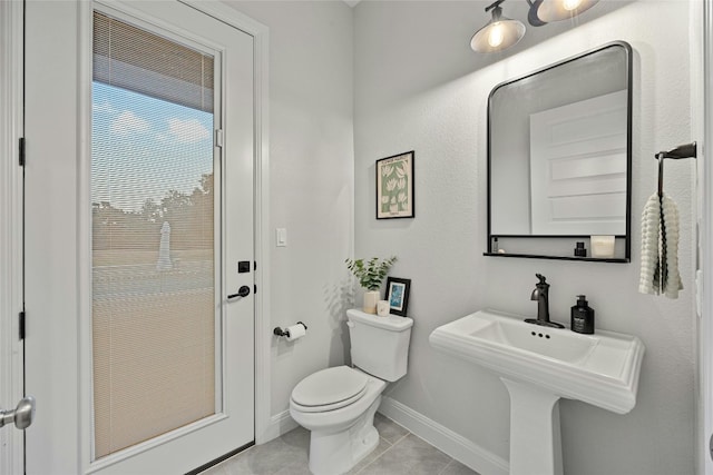 bathroom with toilet and tile patterned flooring