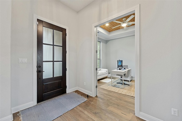 entryway featuring ceiling fan, a raised ceiling, and light hardwood / wood-style flooring