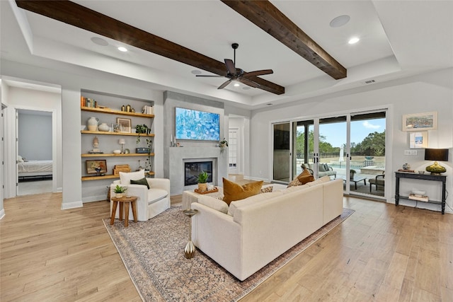 living room with light hardwood / wood-style floors, beam ceiling, and ceiling fan