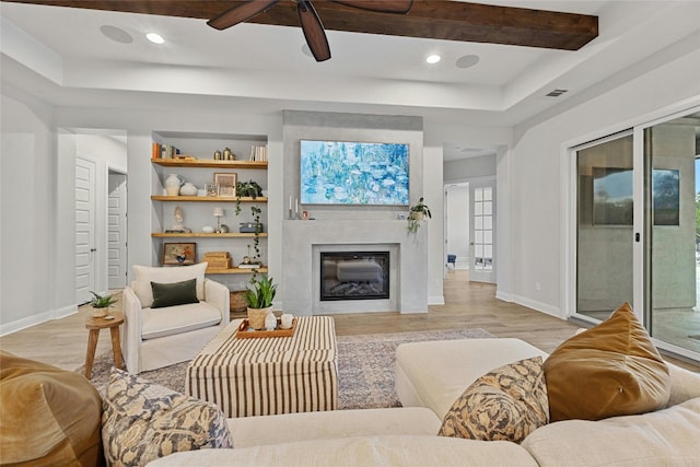 living room featuring beam ceiling, light wood-type flooring, and ceiling fan