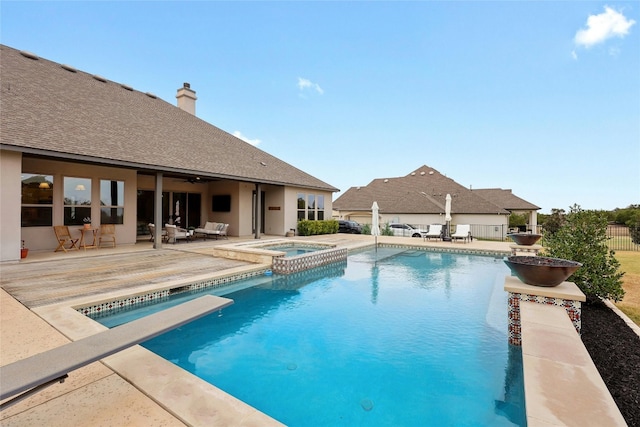 view of swimming pool featuring a patio, an in ground hot tub, and a diving board