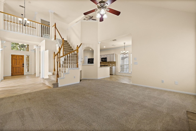 unfurnished living room with ceiling fan, a high ceiling, and light tile patterned floors