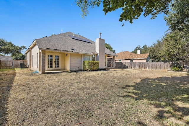 back of property with french doors, a yard, and cooling unit