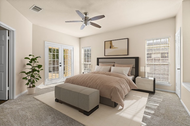 carpeted bedroom featuring french doors, multiple windows, access to exterior, and ceiling fan