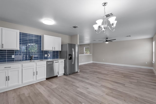 kitchen with backsplash, a healthy amount of sunlight, appliances with stainless steel finishes, and white cabinets