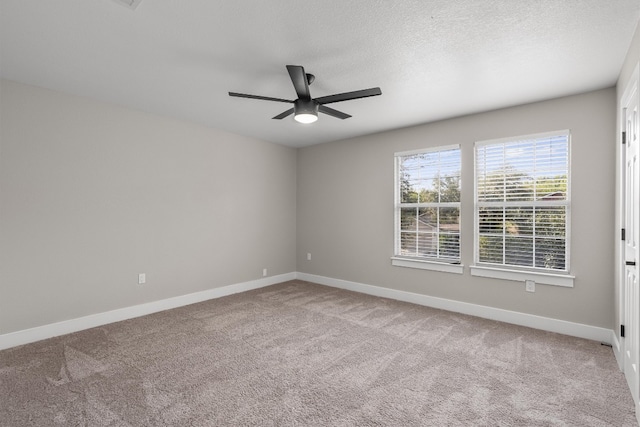 carpeted spare room with a textured ceiling and ceiling fan