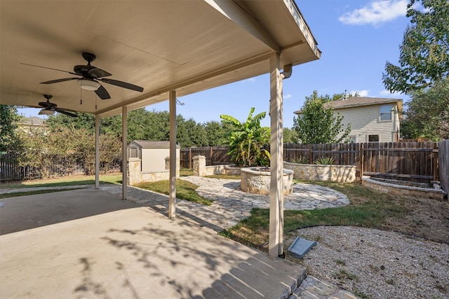 view of patio with a shed, a fire pit, and ceiling fan