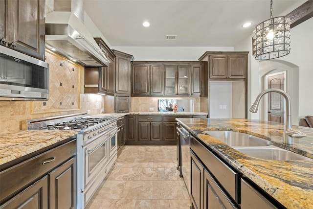 kitchen featuring appliances with stainless steel finishes, sink, dark brown cabinetry, and range hood