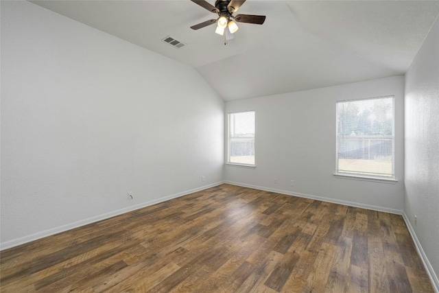 spare room with ceiling fan, vaulted ceiling, plenty of natural light, and dark hardwood / wood-style flooring