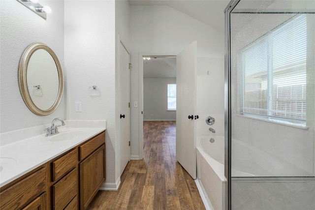 bathroom with vanity, plus walk in shower, wood-type flooring, and vaulted ceiling