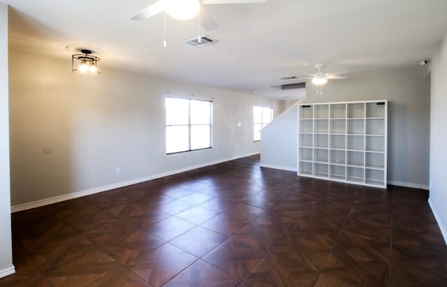 empty room featuring ceiling fan and dark parquet flooring