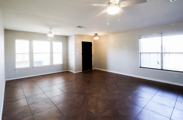 tiled spare room featuring ceiling fan