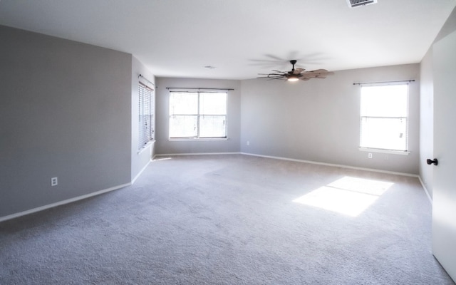 empty room featuring carpet, a healthy amount of sunlight, and ceiling fan