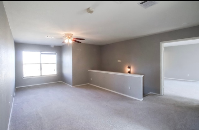 empty room with ceiling fan and light colored carpet