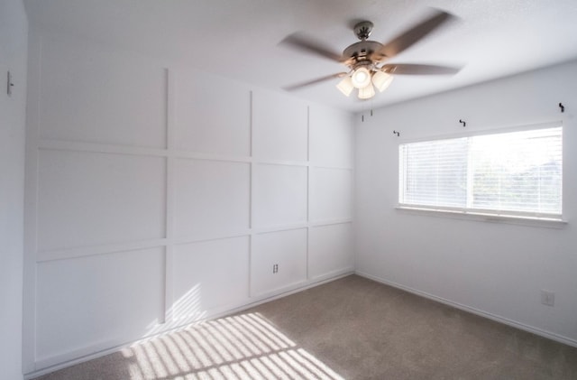 carpeted spare room featuring ceiling fan