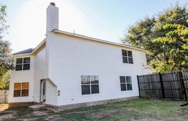 rear view of house featuring a lawn