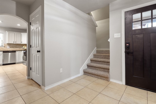 3 Happy Hollow Ln, Wimberley, TX 78676 - entrance foyer featuring light tile patterned floors, arched walkways, baseboards, and stairs