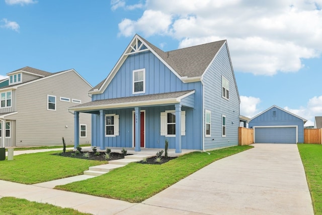 view of front of house featuring a porch, an outdoor structure, a front yard, and a garage