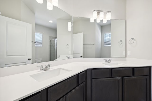 bathroom featuring vanity, toilet, and walk in shower