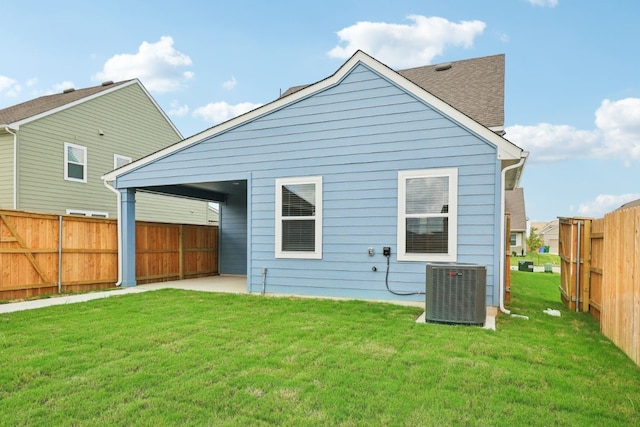 back of house featuring central air condition unit and a lawn