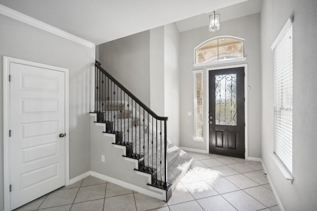 foyer with crown molding, plenty of natural light, and light tile patterned floors