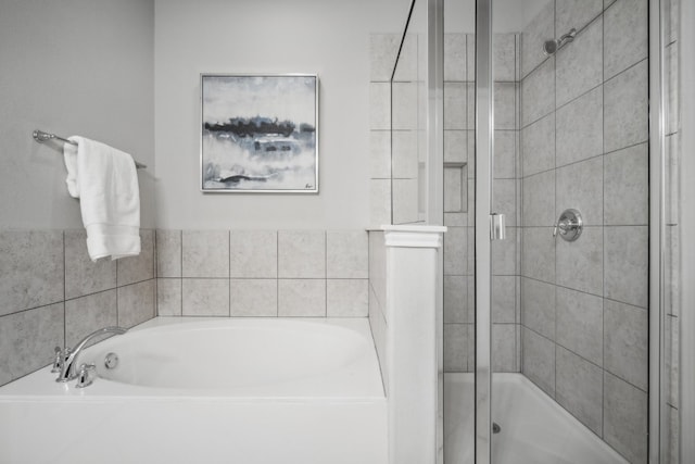 bathroom featuring shower with separate bathtub