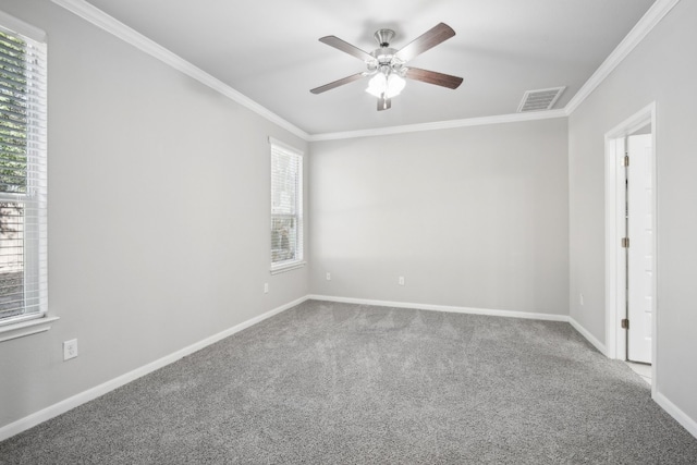 empty room with ornamental molding, a healthy amount of sunlight, and carpet floors