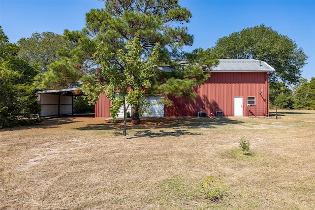 view of yard featuring central air condition unit and an outbuilding