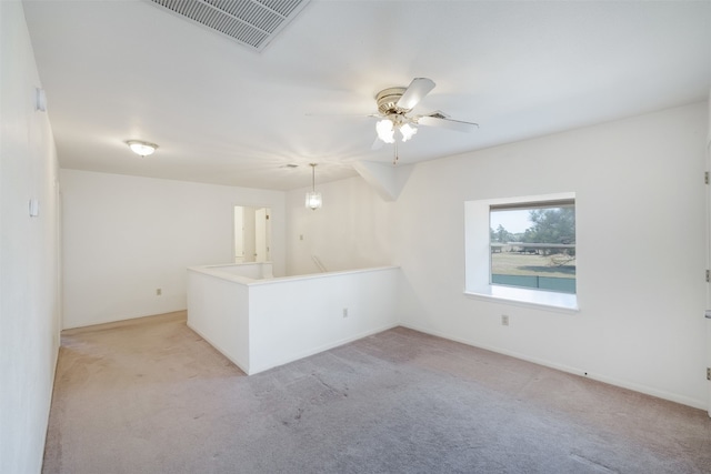 empty room featuring ceiling fan and light colored carpet