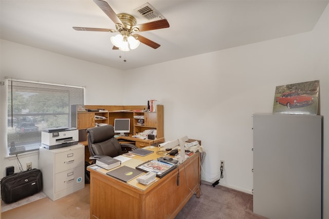 carpeted office space featuring ceiling fan