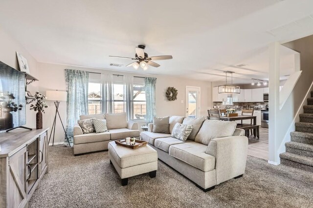 carpeted living room featuring ceiling fan