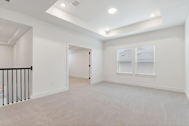 carpeted empty room featuring a raised ceiling