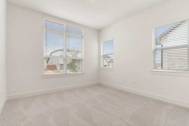 carpeted spare room featuring plenty of natural light