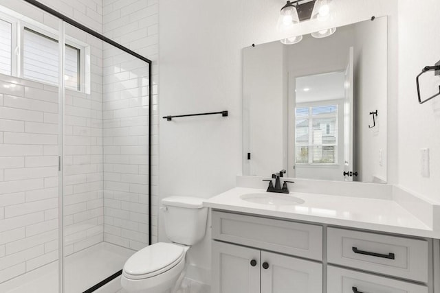 bathroom featuring vanity, toilet, and a shower with door