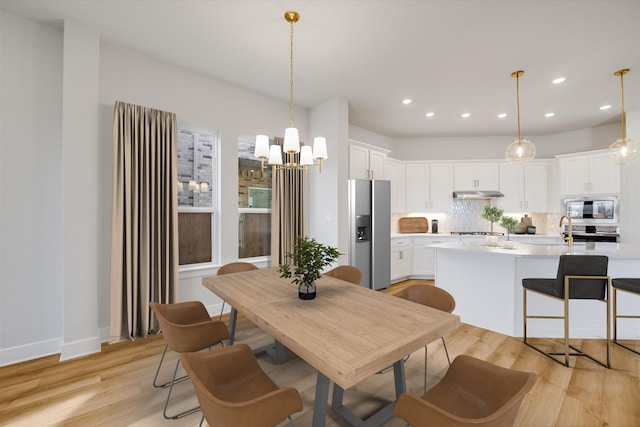 dining space featuring a notable chandelier and light hardwood / wood-style floors