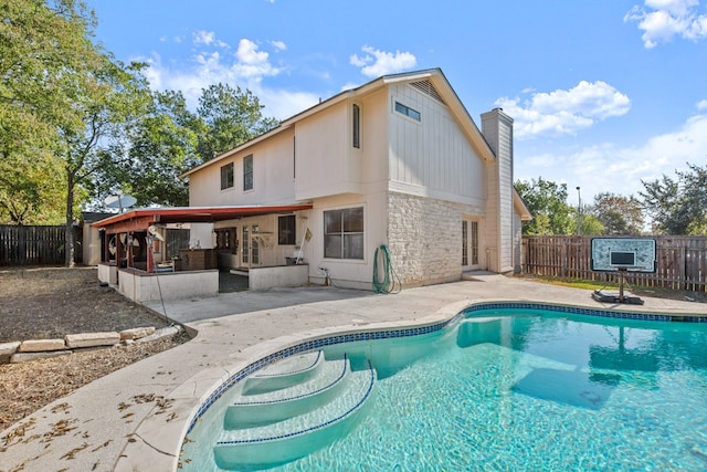 back of property with a patio and a fenced in pool