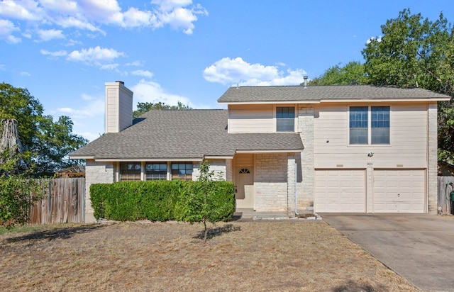 view of front of house featuring driveway, stone siding, a chimney, an attached garage, and fence