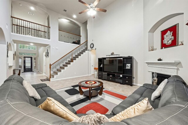 living room featuring light tile patterned flooring, a high ceiling, and ceiling fan