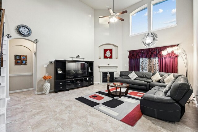 living room with a high ceiling and ceiling fan