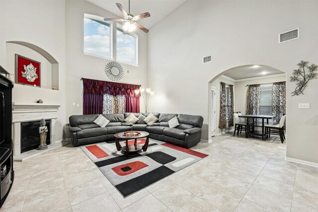 tiled living room featuring ceiling fan, high vaulted ceiling, and ornamental molding