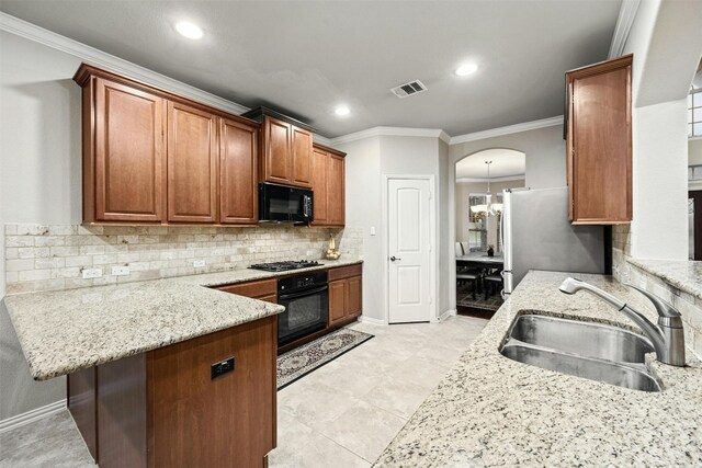 kitchen with light stone countertops, black appliances, sink, kitchen peninsula, and crown molding