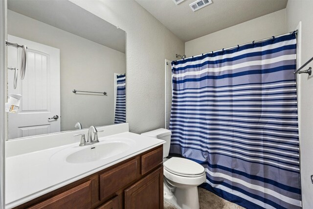 bathroom with vanity, toilet, and a textured ceiling