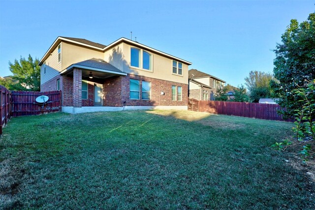 rear view of property featuring a lawn