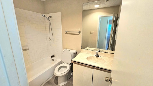 full bathroom with toilet, tiled shower / bath combo, and vanity