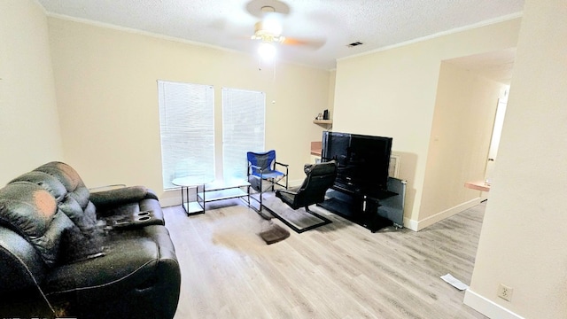 home office with ornamental molding, a textured ceiling, light wood-type flooring, and ceiling fan