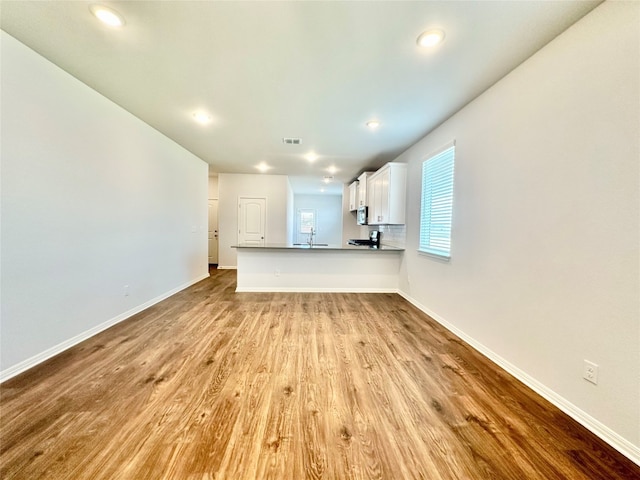 unfurnished living room with sink and light hardwood / wood-style flooring