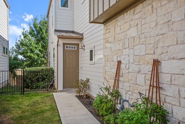 entrance to property featuring a lawn