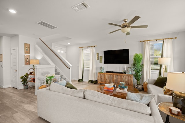 living room with light wood-type flooring and ceiling fan