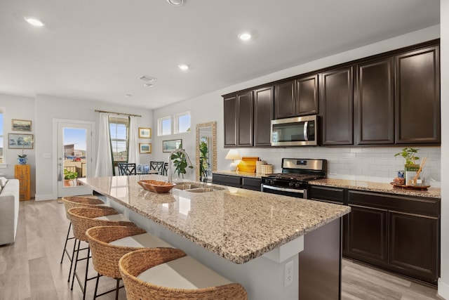 kitchen featuring a center island with sink, appliances with stainless steel finishes, and backsplash