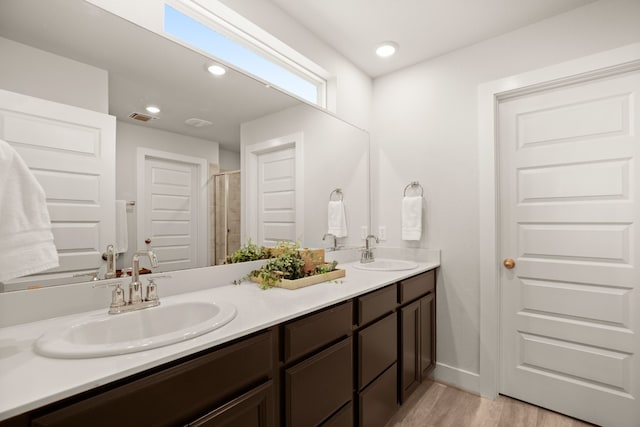 bathroom featuring vanity, hardwood / wood-style flooring, and a shower with shower door